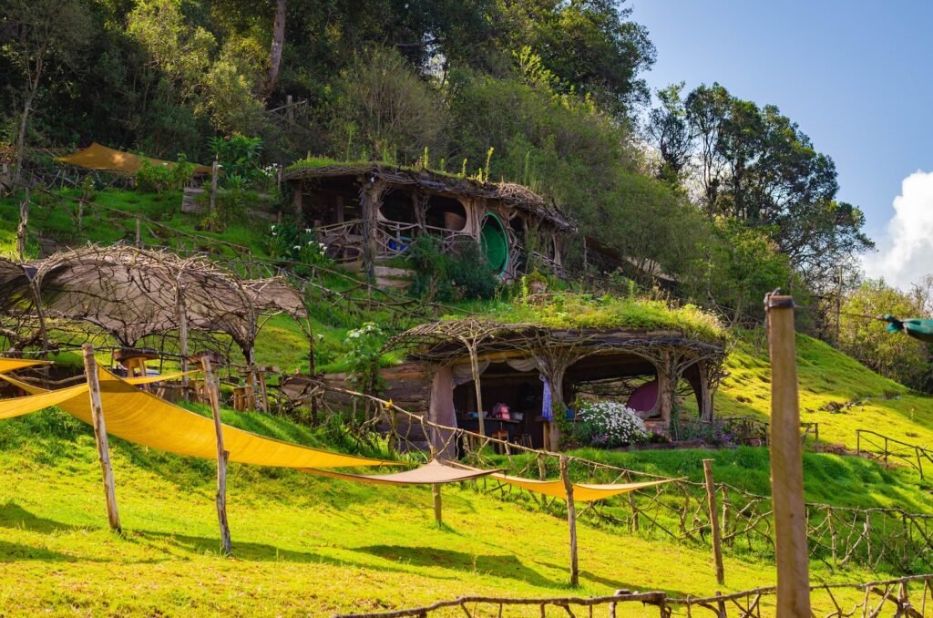 Colina de Hobbitenango | Hospedaje mágico entre montañas de Antigua Vista panorámica de la colina de Hobbitenango con varias habitaciones ecológicas integradas al paisaje montañoso de Antigua Guatemala.